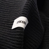 Close-up of Stiksen woven logo label on Black Beanie 01 merino wool beanie