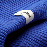 Close-up of Stiksen woven logo label on Cobalt Beanie 01 merino wool beanie