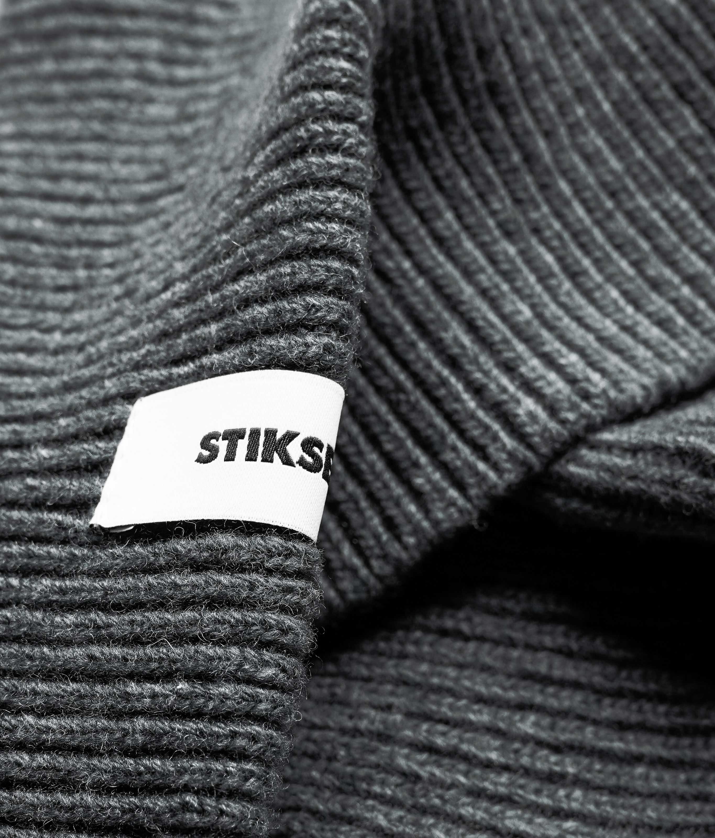 Close-up of Stiksen woven logo label on Dark Grey Beanie 01 merino wool beanie