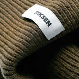 Close-up of Stiksen woven logo label on Ivy Beanie 01 merino wool beanie