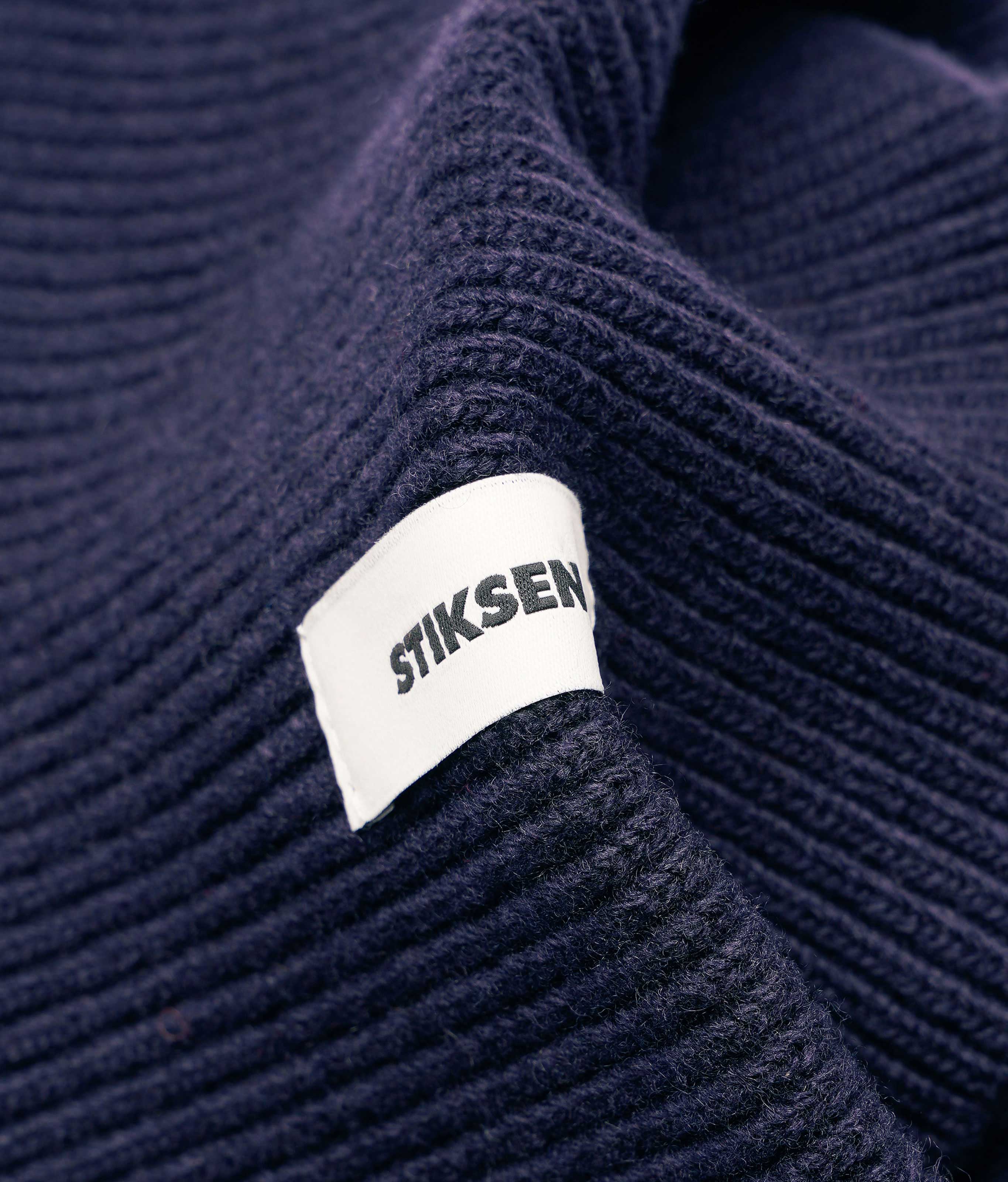 Close-up of Stiksen woven logo label on Navy Beanie 01 merino wool beanie