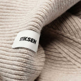 Close-up of Stiksen woven logo label on Sand Beanie 01 merino wool beanie