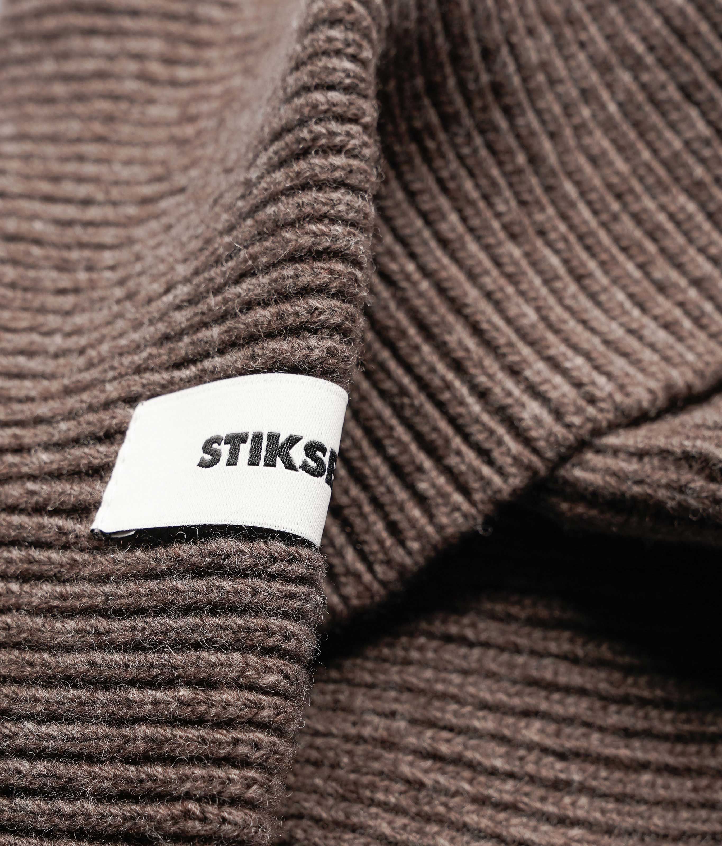 Close-up of Stiksen woven logo label on Taupe Beanie 01 merino wool beanie