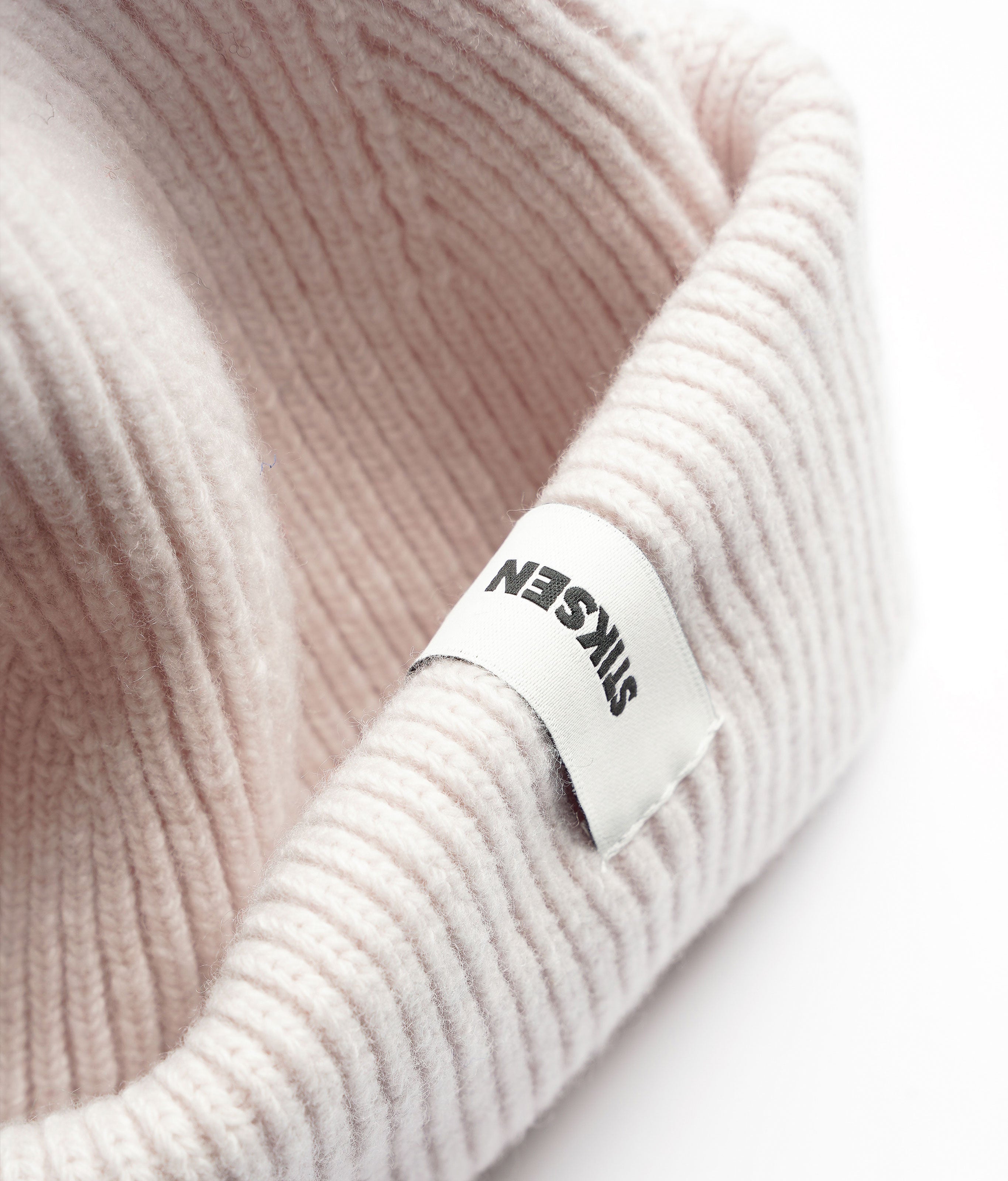 Close-up of Stiksen woven logo label on White Beanie 01 merino wool beanie