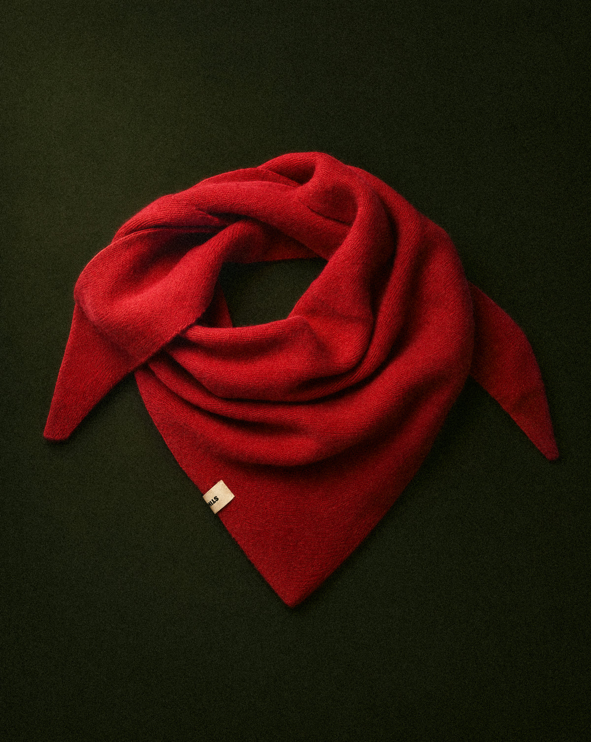 Red triangular shaped scarf wrapped displayed on a flat surface