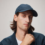 Stiksen 105 Ventile Midnight Blue dad cap worn by male model in soft indoor lighting