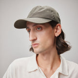 Stiksen 105 Ventile Moss Green dad cap worn by male model in soft indoor lighting