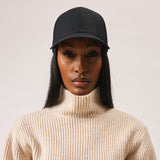 Stiksen 107 Ventile Black baseball cap worn by female model in soft indoor lighting