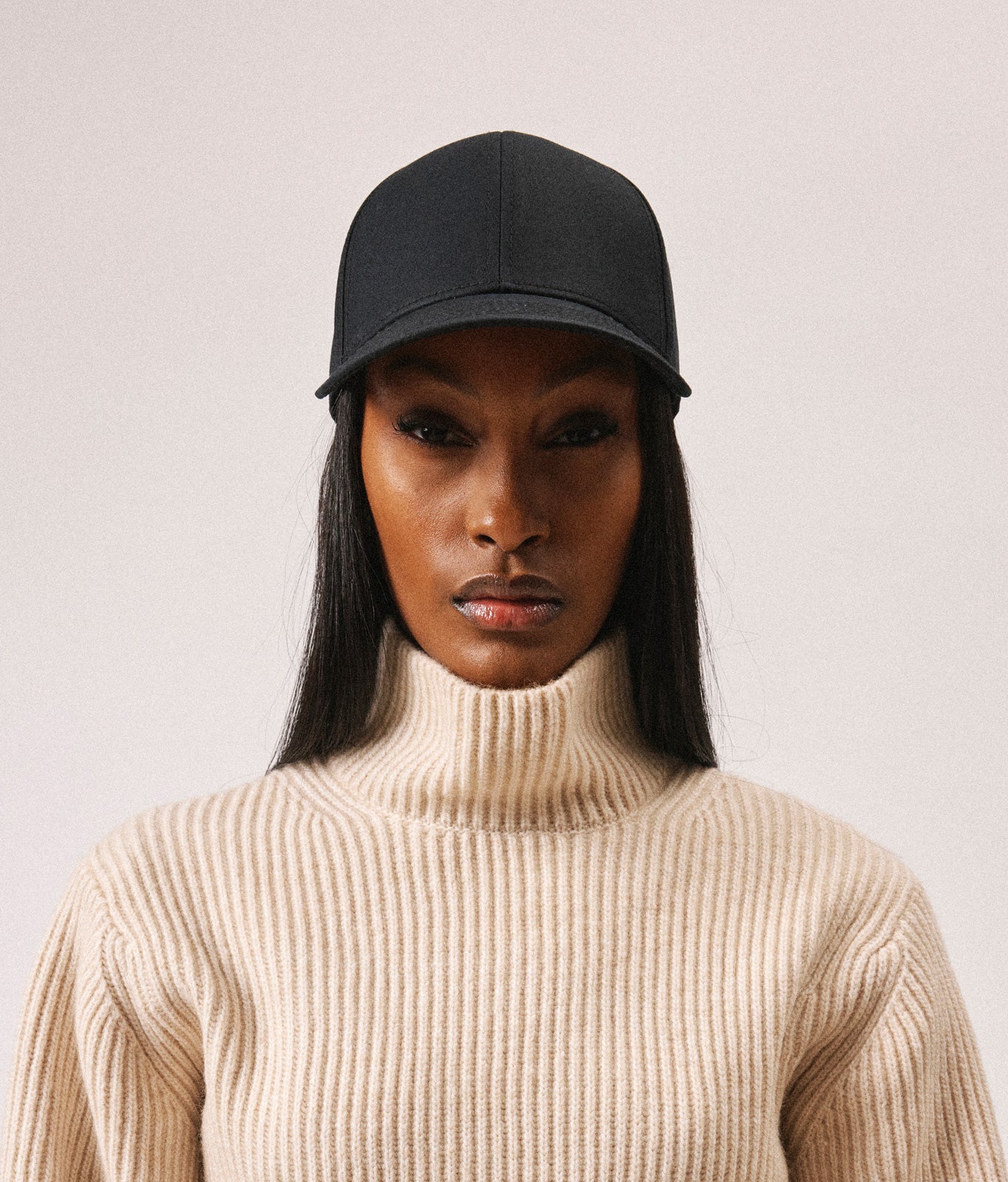 Stiksen 107 Ventile Black baseball cap worn by female model in soft indoor lighting