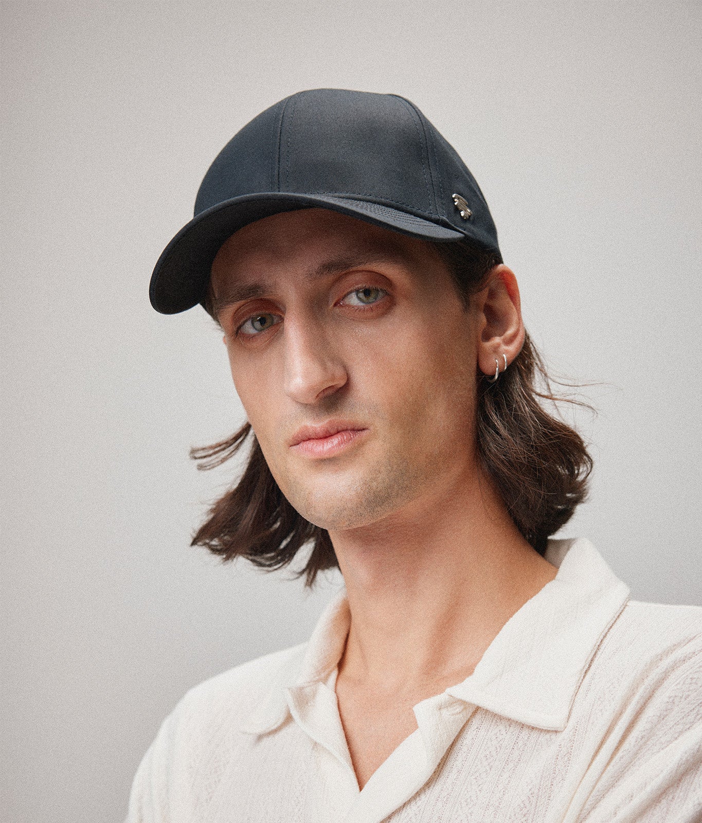 Stiksen 107 Ventile Black baseball cap worn by male model in soft indoor lighting