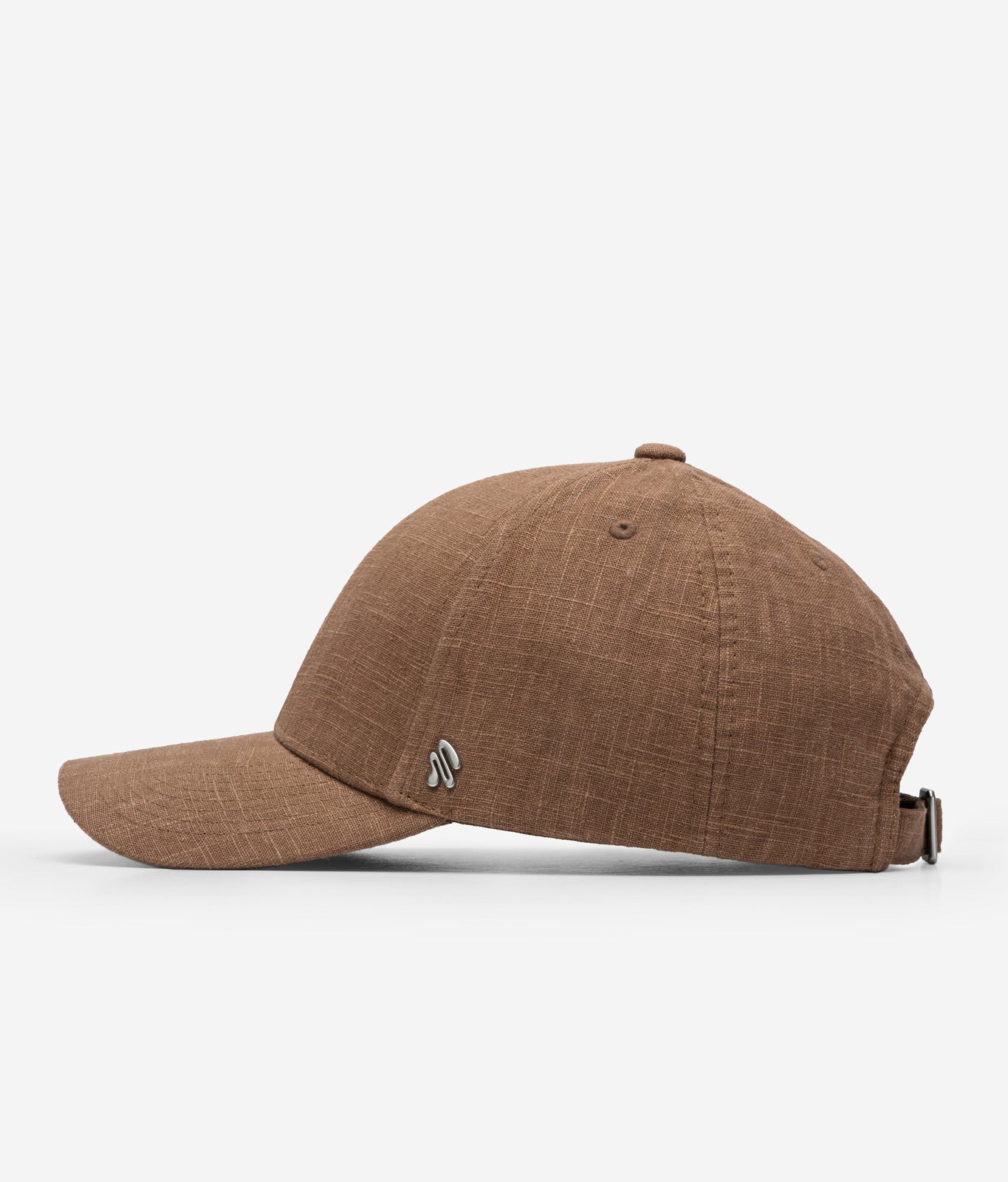 Brown linen baseball cap side view with curved brim and metal logo detail