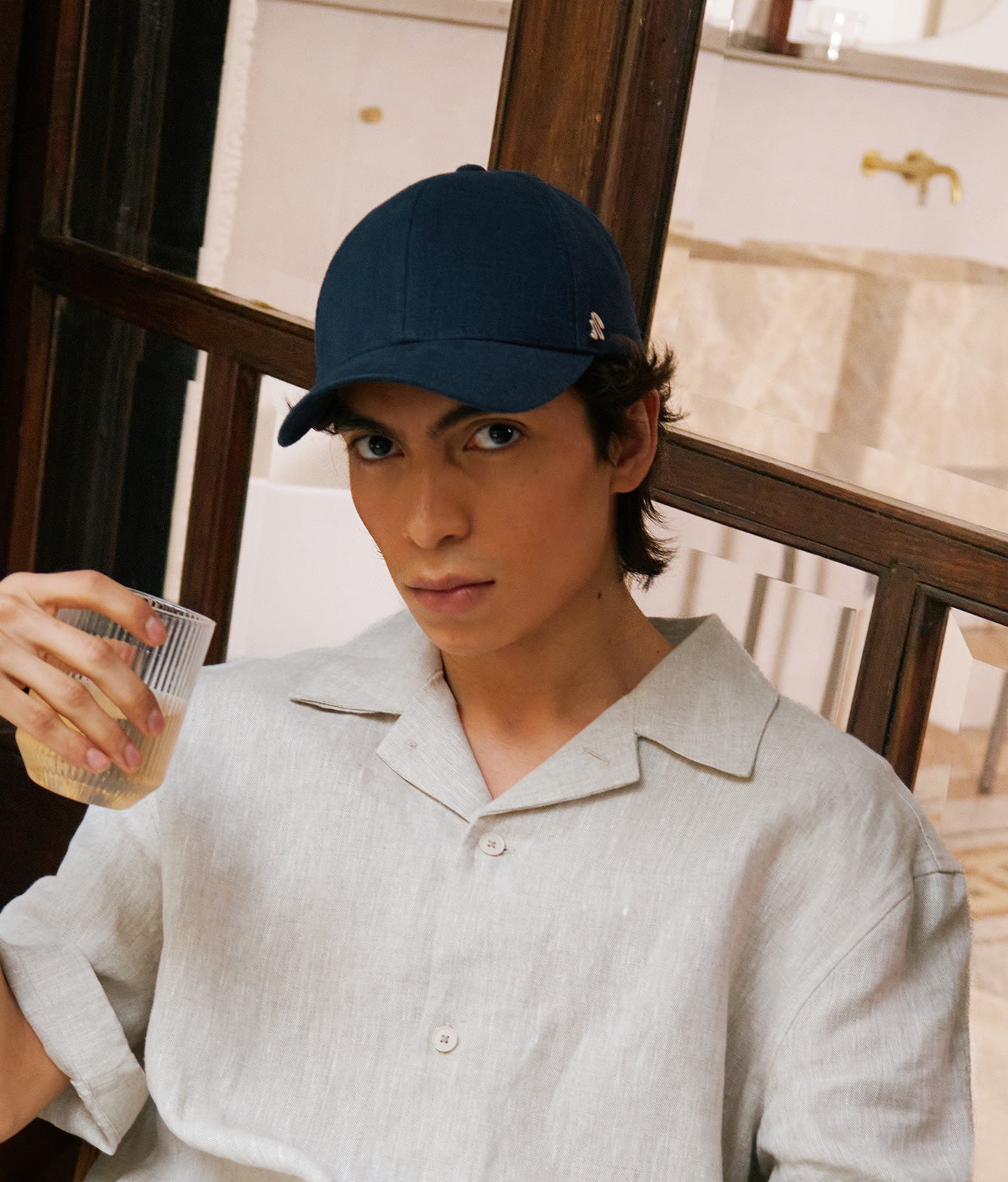 Stiksen 107 Linen Indigo baseball cap worn by model indoors in warm ambient lighting