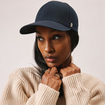 Stiksen 107 Ventile Midnight Blue baseball cap worn by female model in warm indoor lighting
