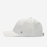White linen baseball cap side view with curved brim and metal logo detail